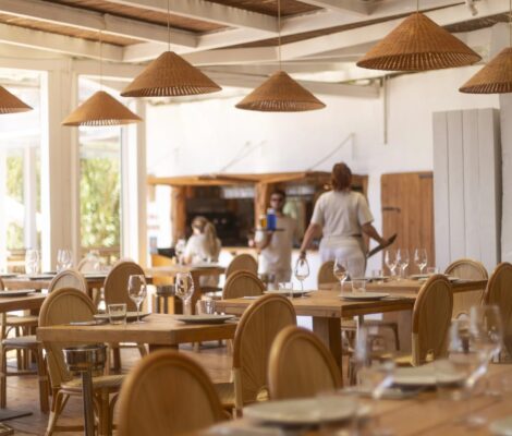 De lichte eetzaal van Cala Bonita met rieten lampen en houten tafels