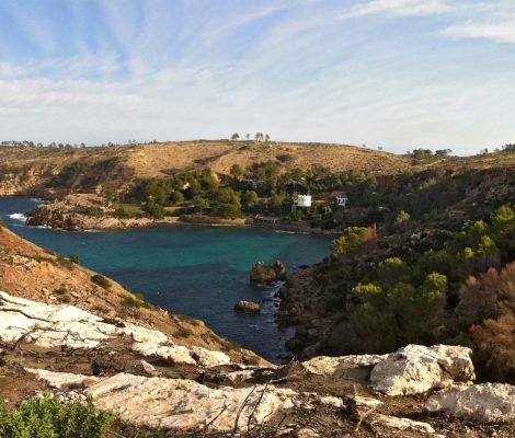 De baai van Es Canaret op de noordkust van Ibiza, met turquoise water, de witte villa met toren en daarachter de punta de Xarracó