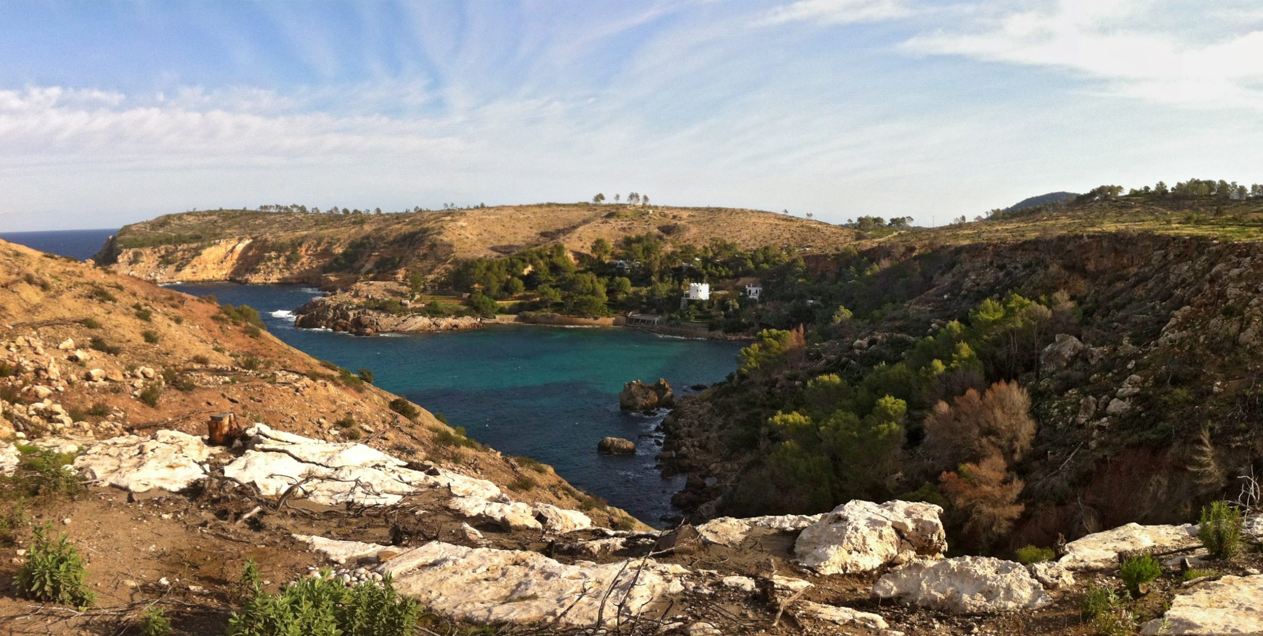 Cala es Canaret Ibiza: verborgen baai bij Portinatx, met de wandeling en de toegang in 2026 1 De baai van Es Canaret op de noordkust van Ibiza, met turquoise water, de witte villa met toren en daarachter de punta de Xarracó