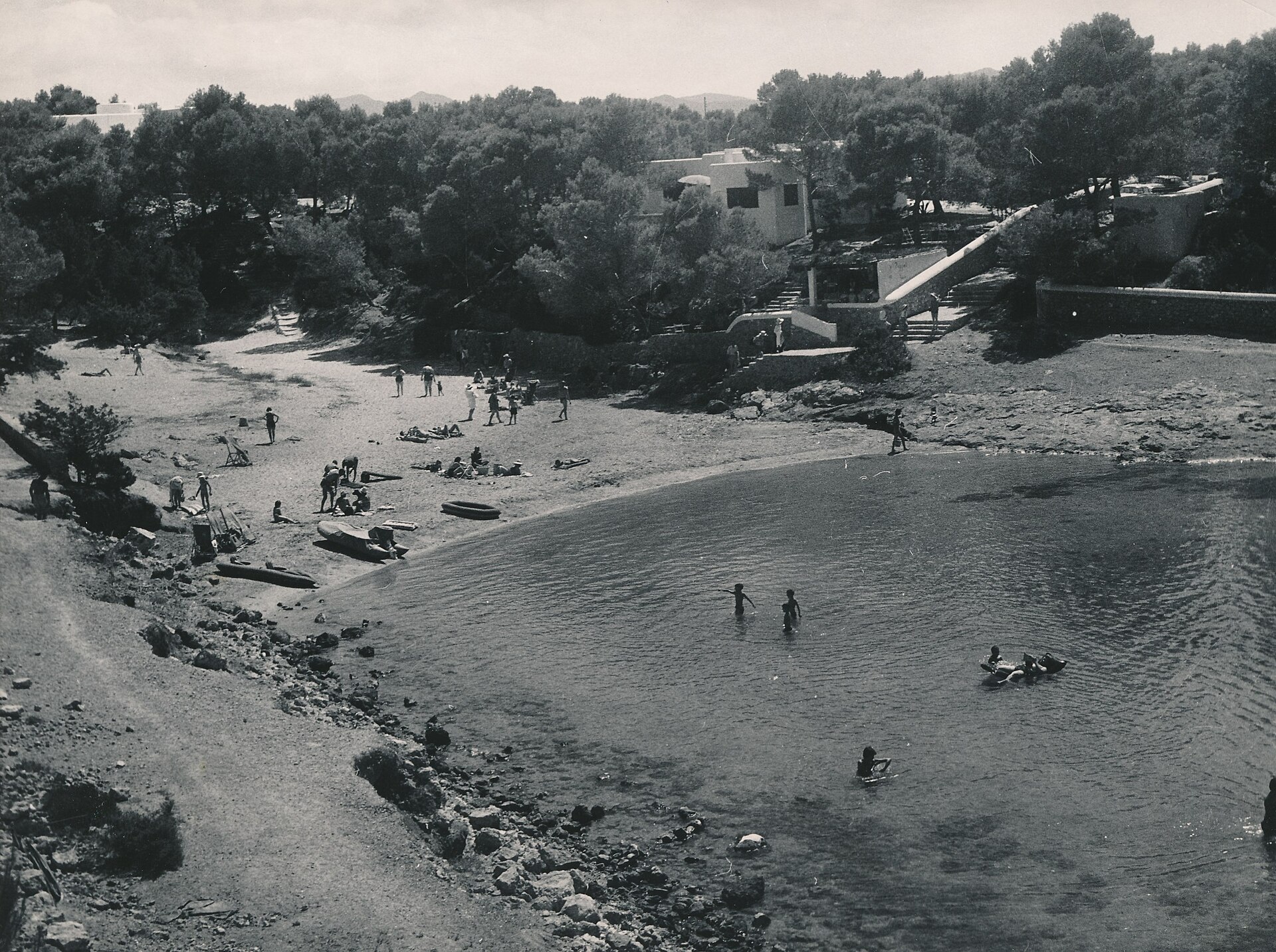 Zwart-witfoto van Cala Gració bij Sant Antoni rond 1960 met badgasten op het zand