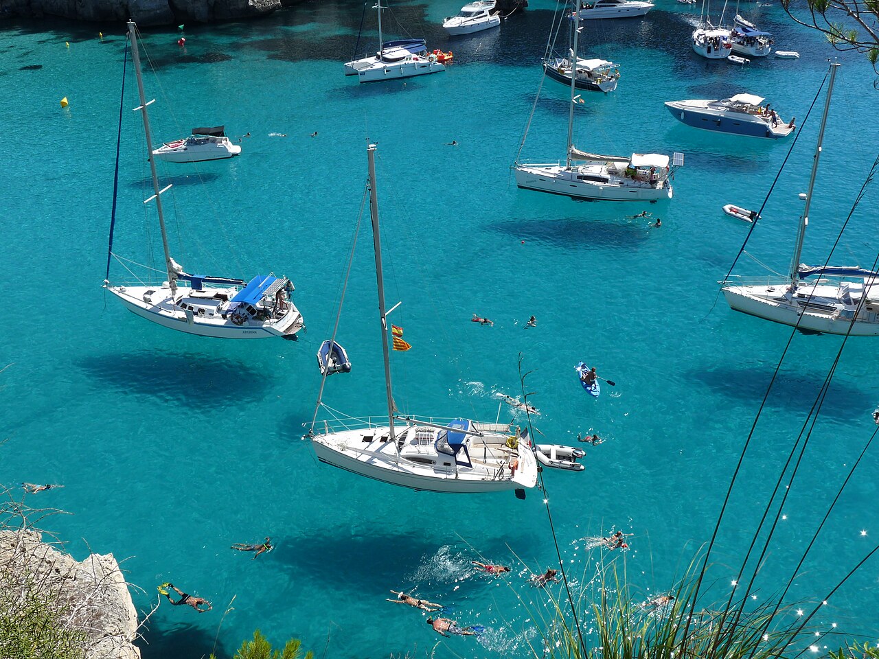 Cala Macarella op Menorca met boten in helder turquoise water