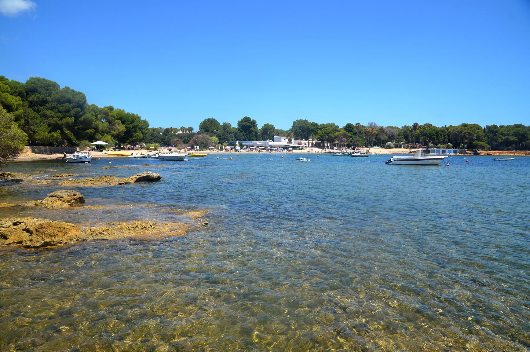 Helder water over rotsplaten aan de rand van Cala Pada op Ibiza