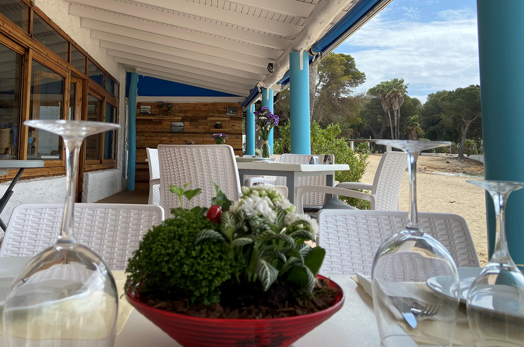 Gedekte tafel op het overdekte terras aan het strand van Cala Pada