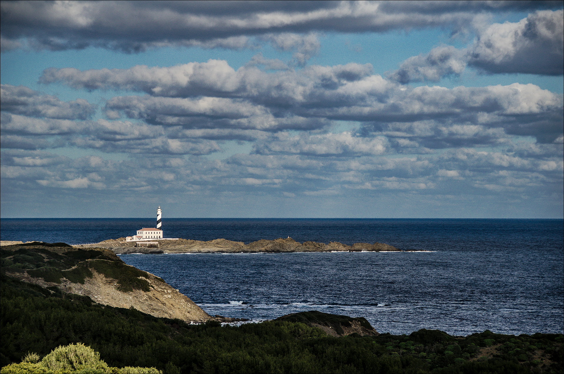 Camí de Cavalls Menorca: het pad van 185 km rond het eiland 3 Uitzicht vanaf het Camí de Cavalls op de vuurtoren van Favàritx aan de donkere noordoostkust van Menorca