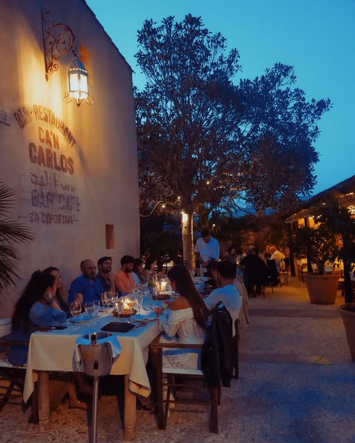 Diner in de verlichte tuin van Can Carlos in de avond