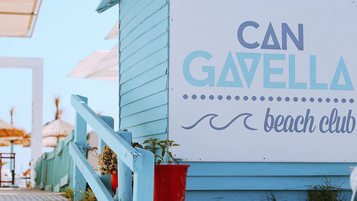 Can Gavella Mallorca: de chiringuito op het zand van Playa de Muro 4 Het naambord van Can Gavella beach club op de turquoise houten gevel