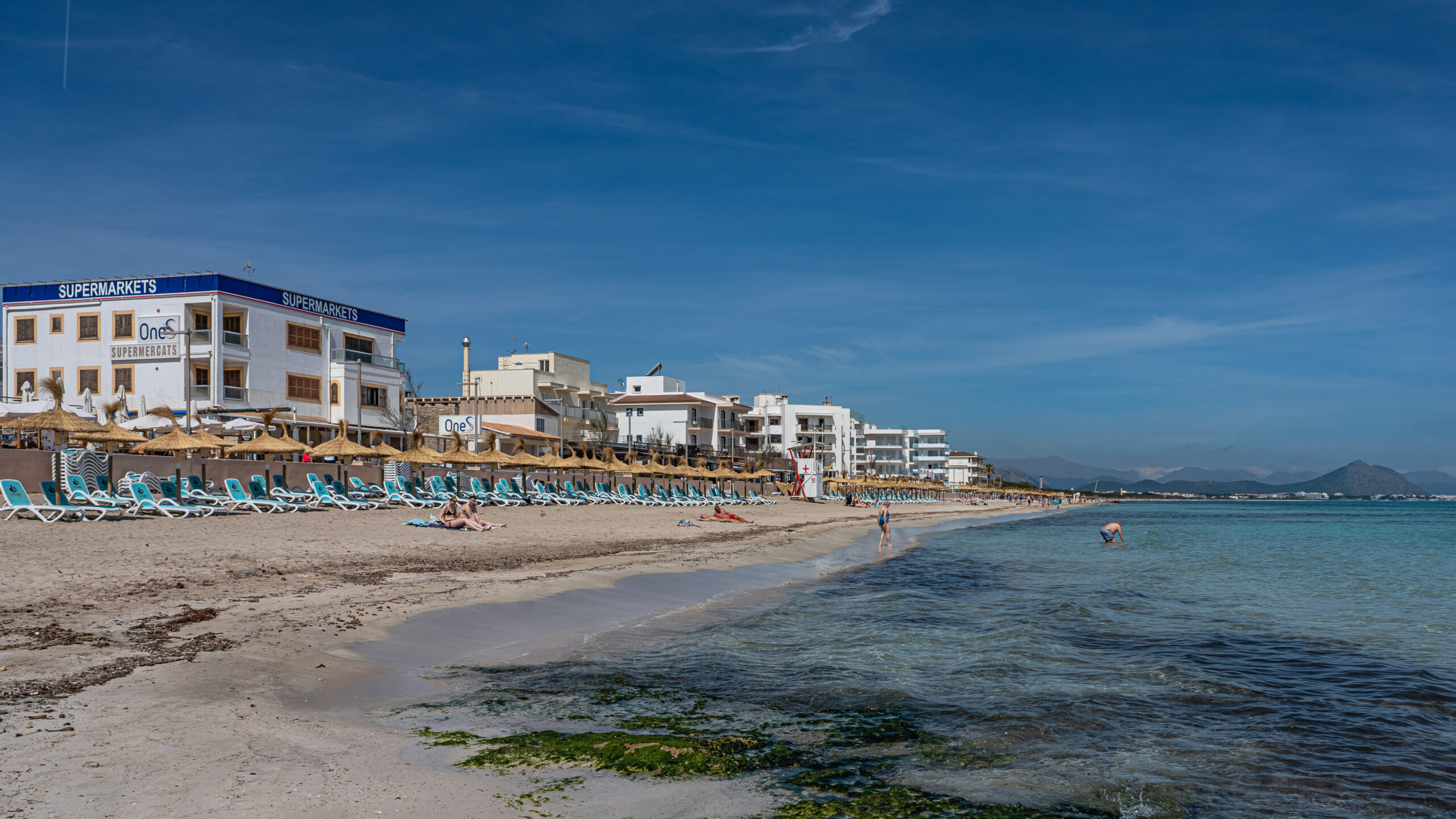 Can Picafort Mallorca: stranden, boulevard en s'Albufera 1 Het brede zandstrand van Can Picafort met ligbedden, hotels langs de boulevard en helder water