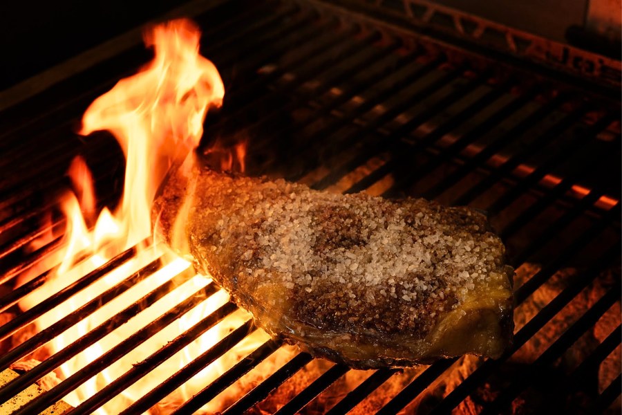 Een chuletón boven de vlammen van de Josper-houtskoolgrill bij o96