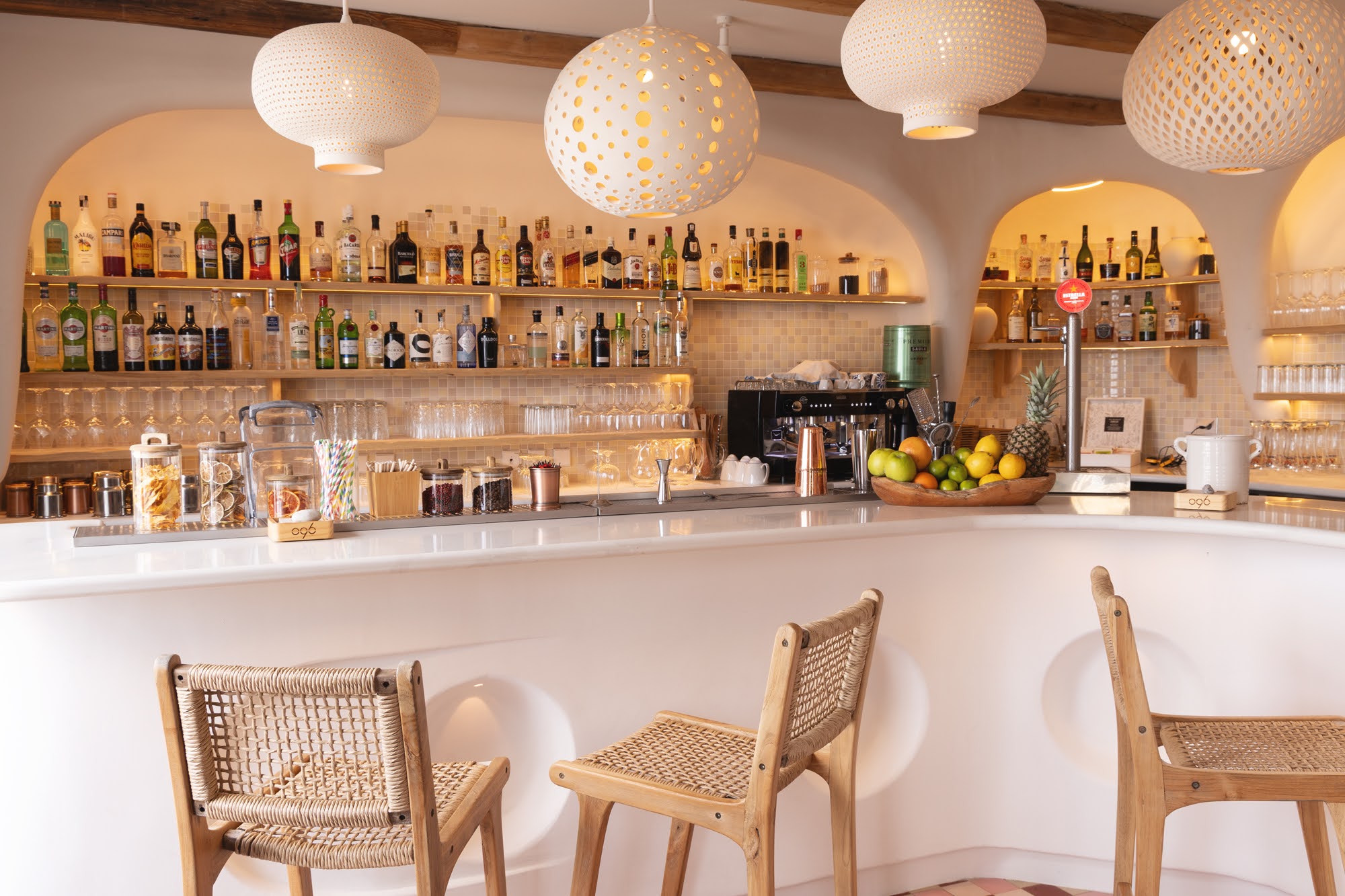 De cocktailbar van o96 met ronde lampen en flessen op de achterwand