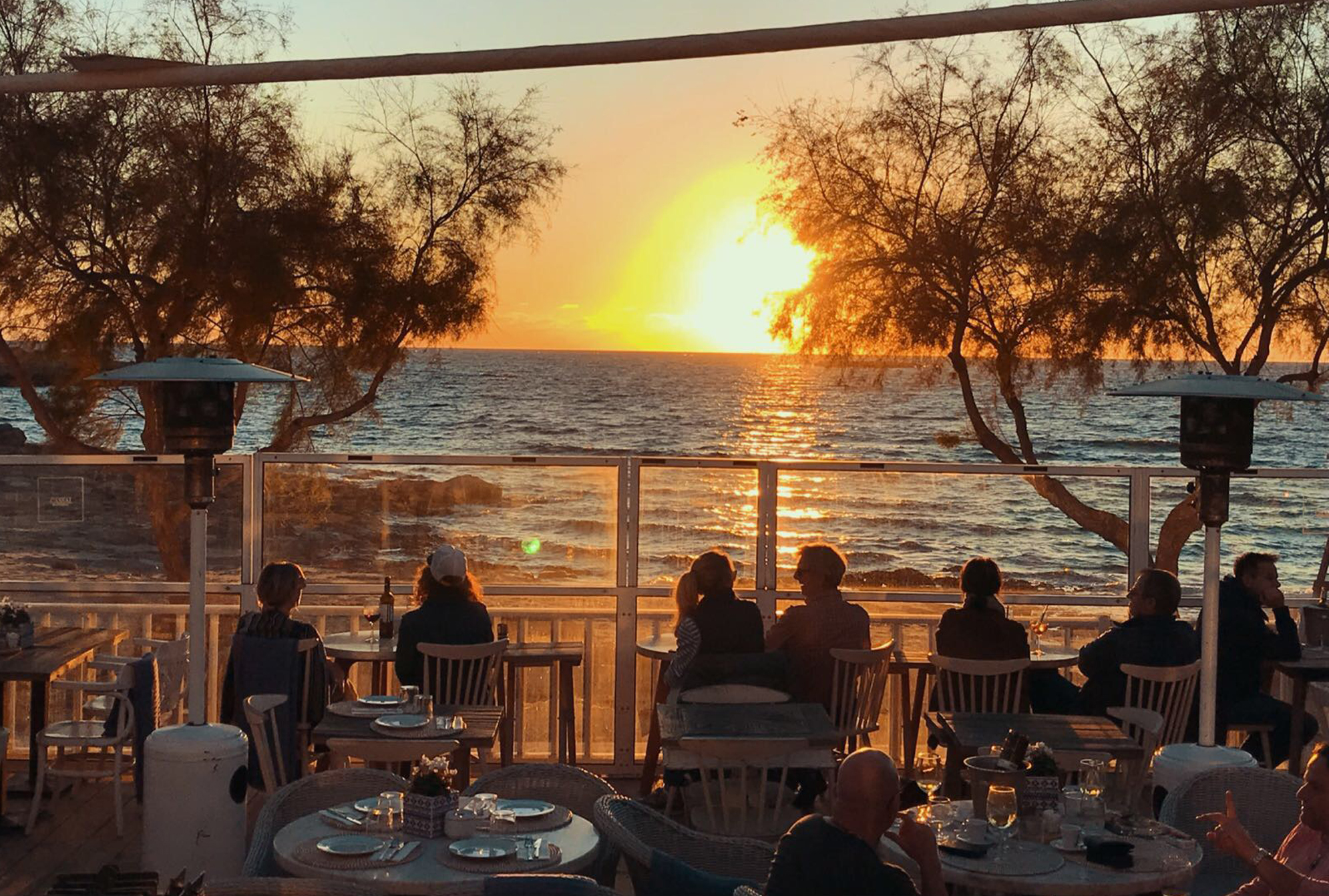 Het terras van Cassai Beach House bij zonsondergang met uitzicht over de zee