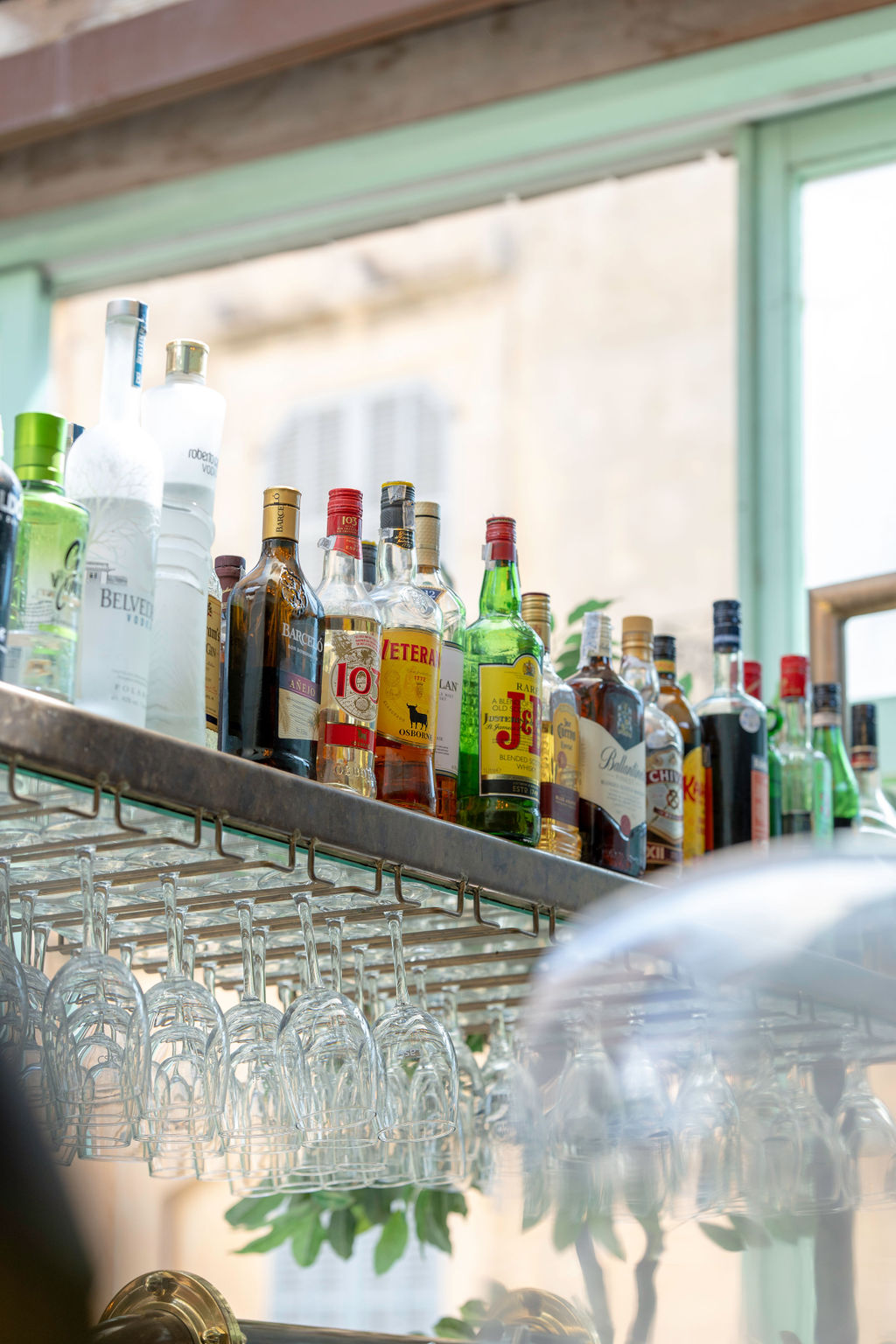 Cassai Gran Café Ses Salines: mediterraan eten in een oud dorpspand 5 De bar met flessen en glazen van Cassai Gran Café in Ses Salines