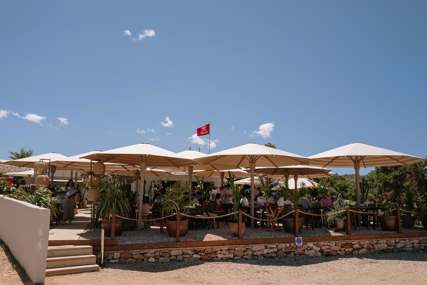 Chezz Gerdi Formentera: het iconische strandrestaurant van Es Pujols 2 Het terras met parasols van Chezz Gerdi aan het strand van Es Pujols met de zee erachter