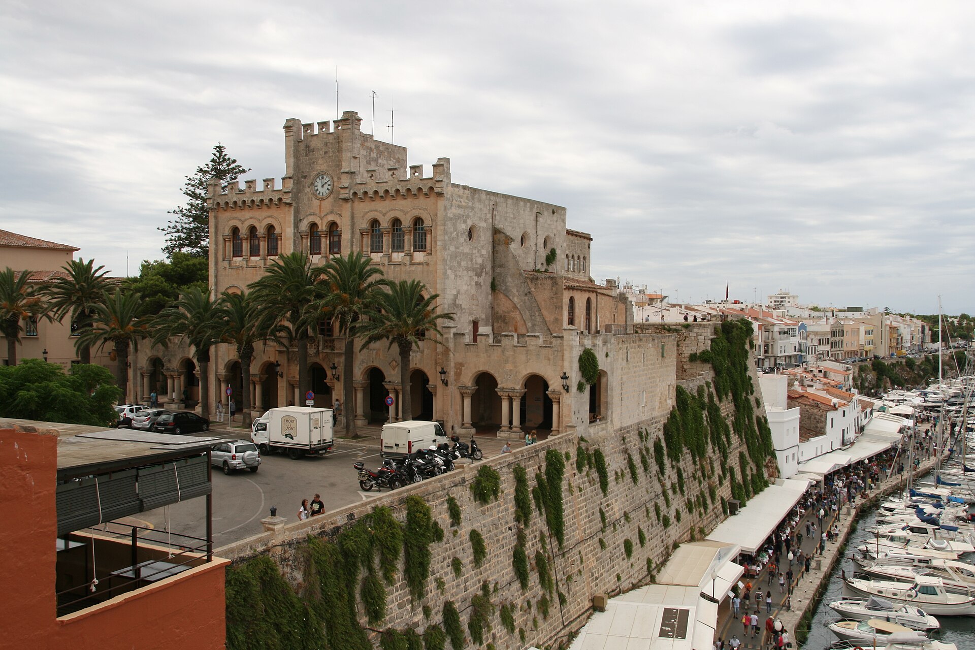 Het stadhuis van Ciutadella op de oude stadsmuur boven de haven met de kade en de boten op Menorca