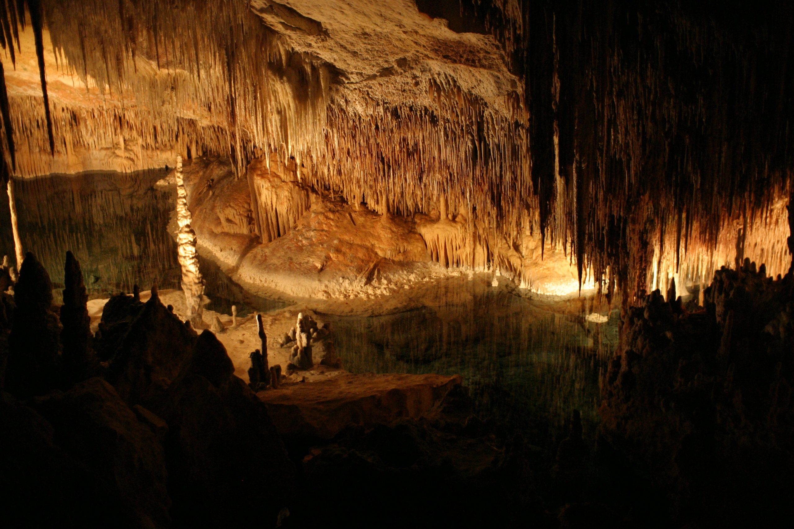 Warm uitgelichte stalactietengordijnen in het interieur van de Coves del Drac op Mallorca