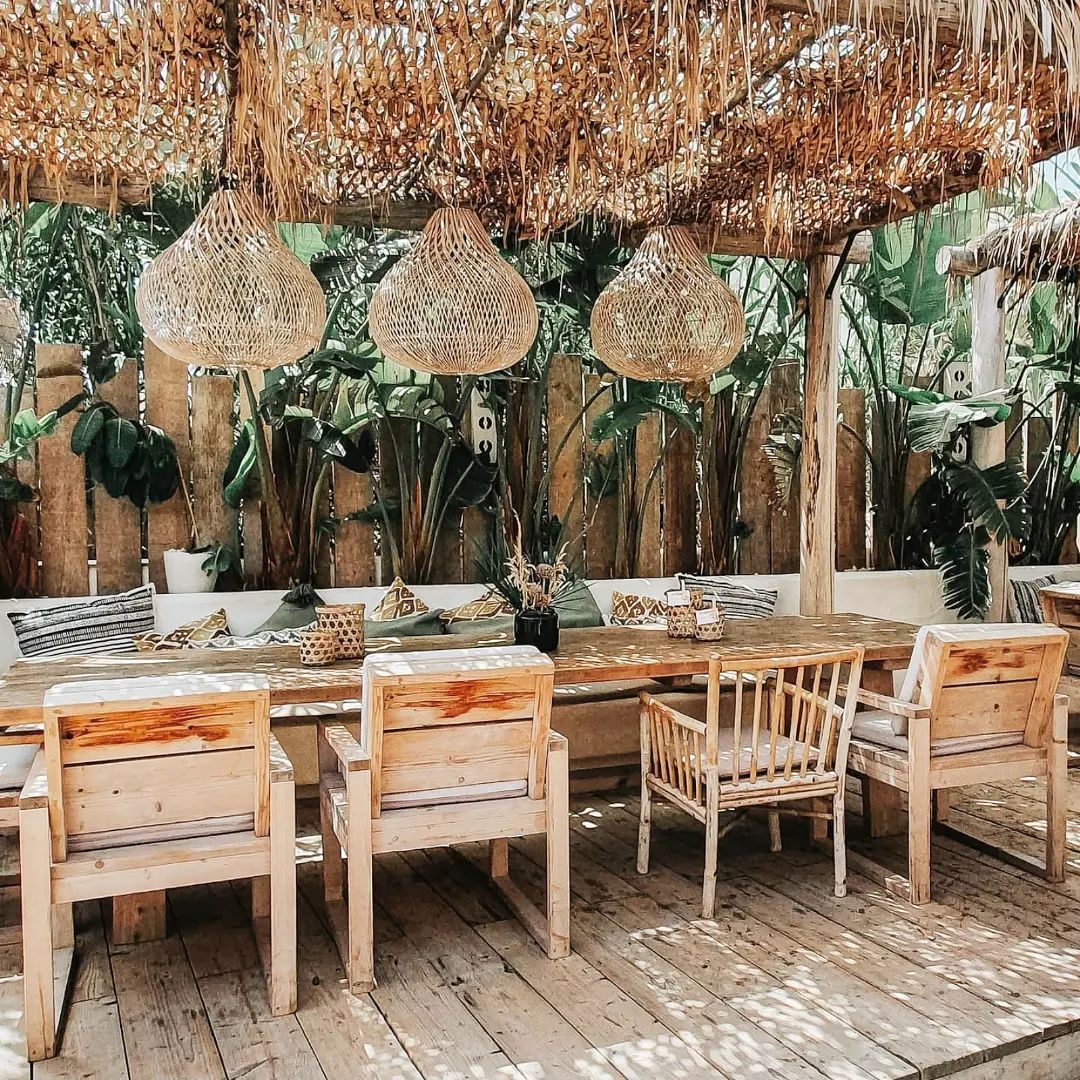 Gedekte houten tafel met planten op het terras van Cucum Beach House