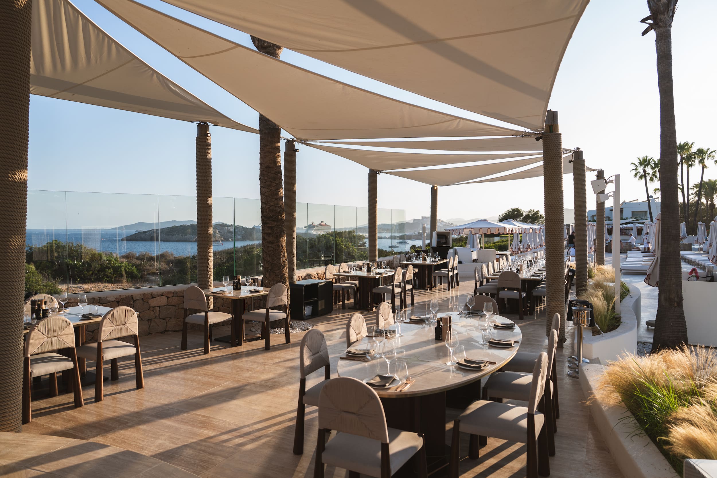 Destino Ibiza: van Destino Pacha naar Destino Five, en wat er veranderde 9 Terrasrestaurant bij Destino met doeken tegen de zon en uitzicht op zee
