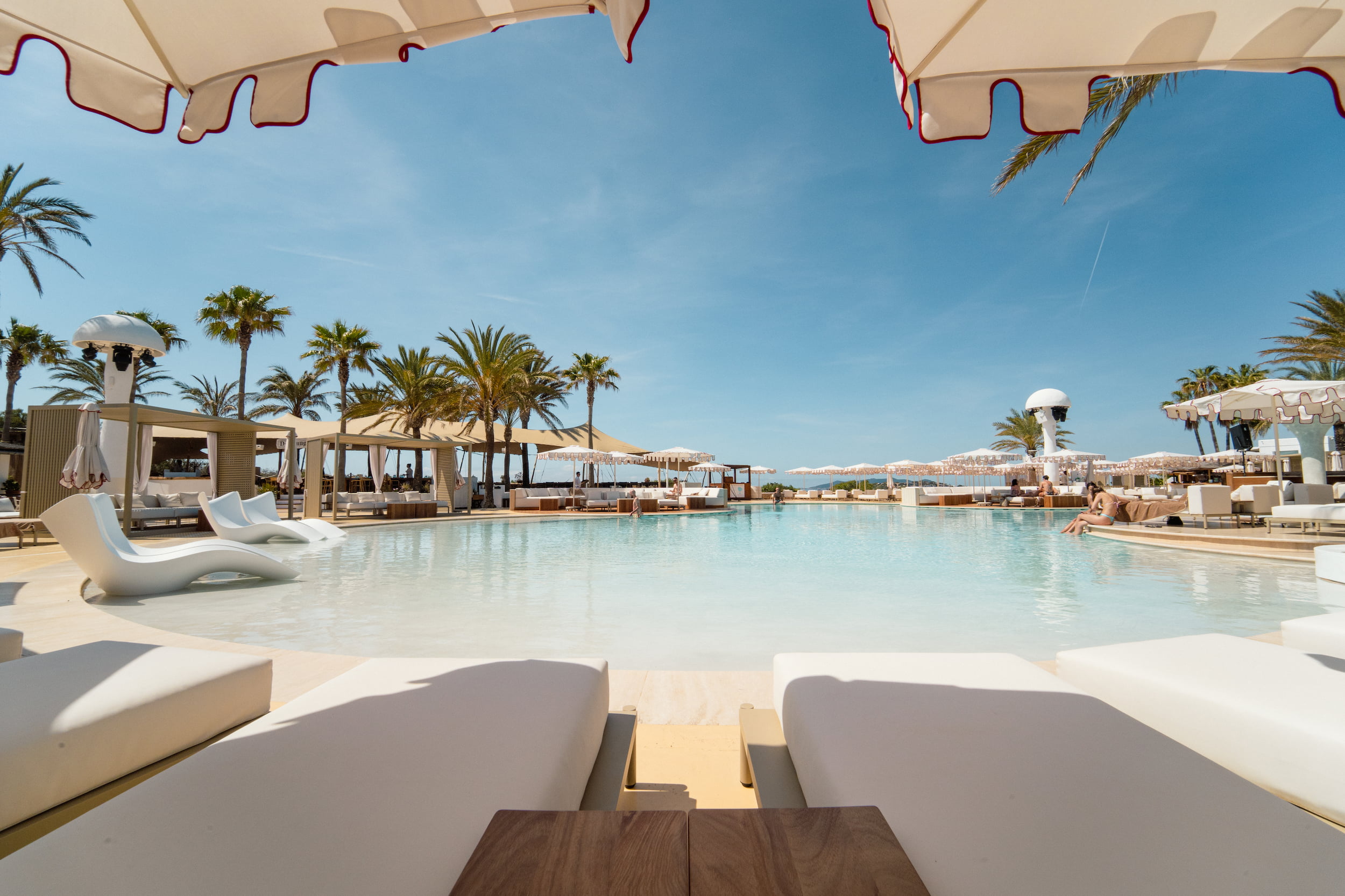Destino Ibiza: van Destino Pacha naar Destino Five, en wat er veranderde 5 Het zwembadterras van Destino Five Ibiza met palmen en ligbedden