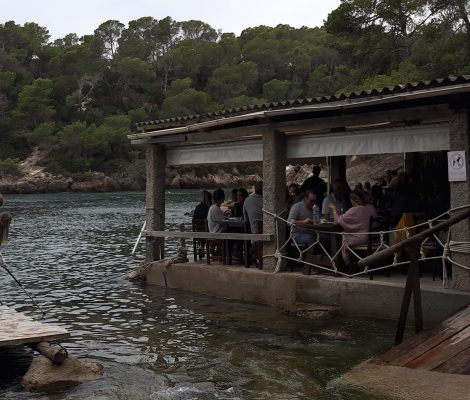 Het restaurant El Bigotes aan het water van Cala Mastella, met een houten steiger ervoor