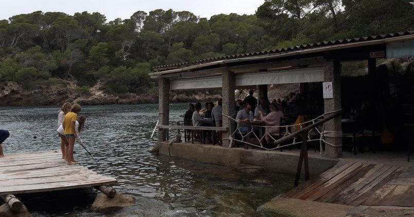 Het restaurant El Bigotes aan het water van Cala Mastella, met een houten steiger ervoor