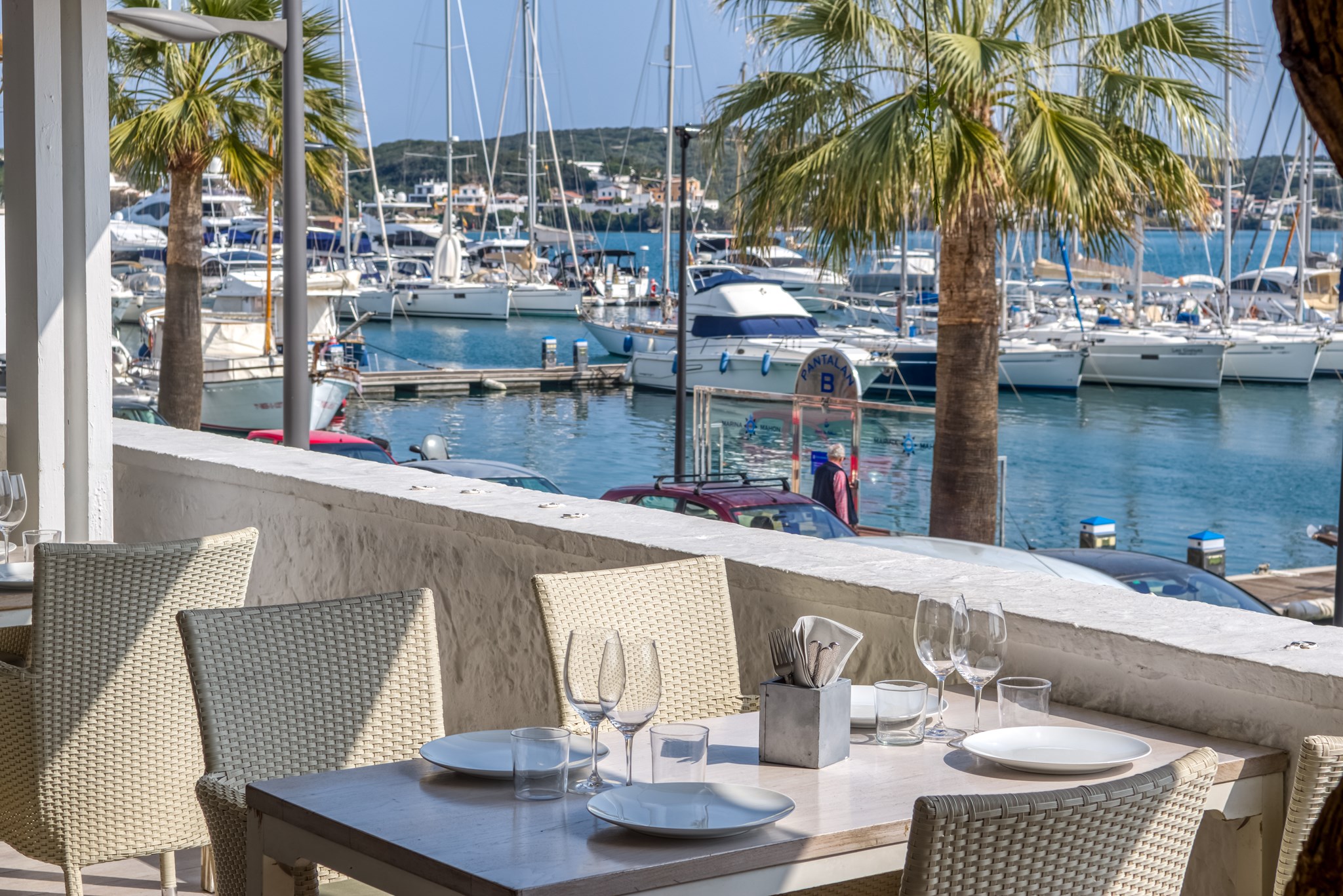 Gedekte tafel op het terras van El Rais met de jachthaven van Maó op de achtergrond