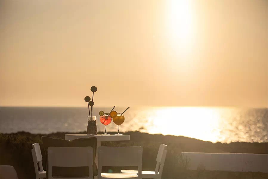 Tafel met cocktails op het terras van Eolo Sunset Bar bij zonsondergang