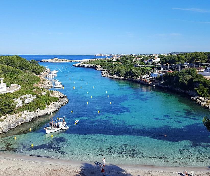 Het beschutte baaitje Cala Santandría met helder water bij Es Bruc