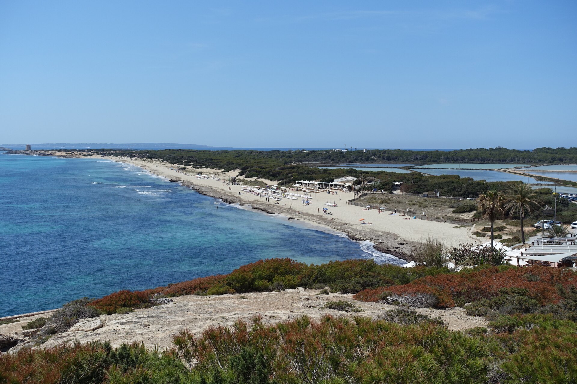 Uitzicht van bovenaf over het lange zandstrand van Es Cavallet op Ibiza met duinen en turquoise water