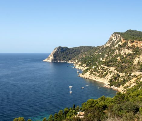 Uitzicht vanaf Es Cubells over de steile, beboste kliffen van de zuidwestkust van Ibiza en de diepblauwe zee