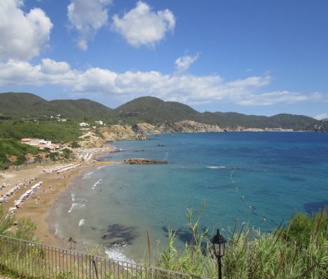 Het strand van Es Figueral van bovenaf gezien, met Aigües Blanques en de noordoostkust van Ibiza op de achtergrond