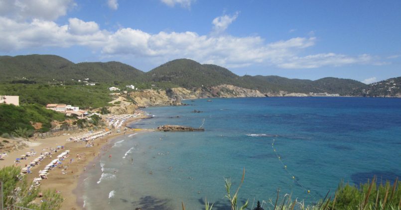 Het strand van Es Figueral van bovenaf gezien, met Aigües Blanques en de noordoostkust van Ibiza op de achtergrond
