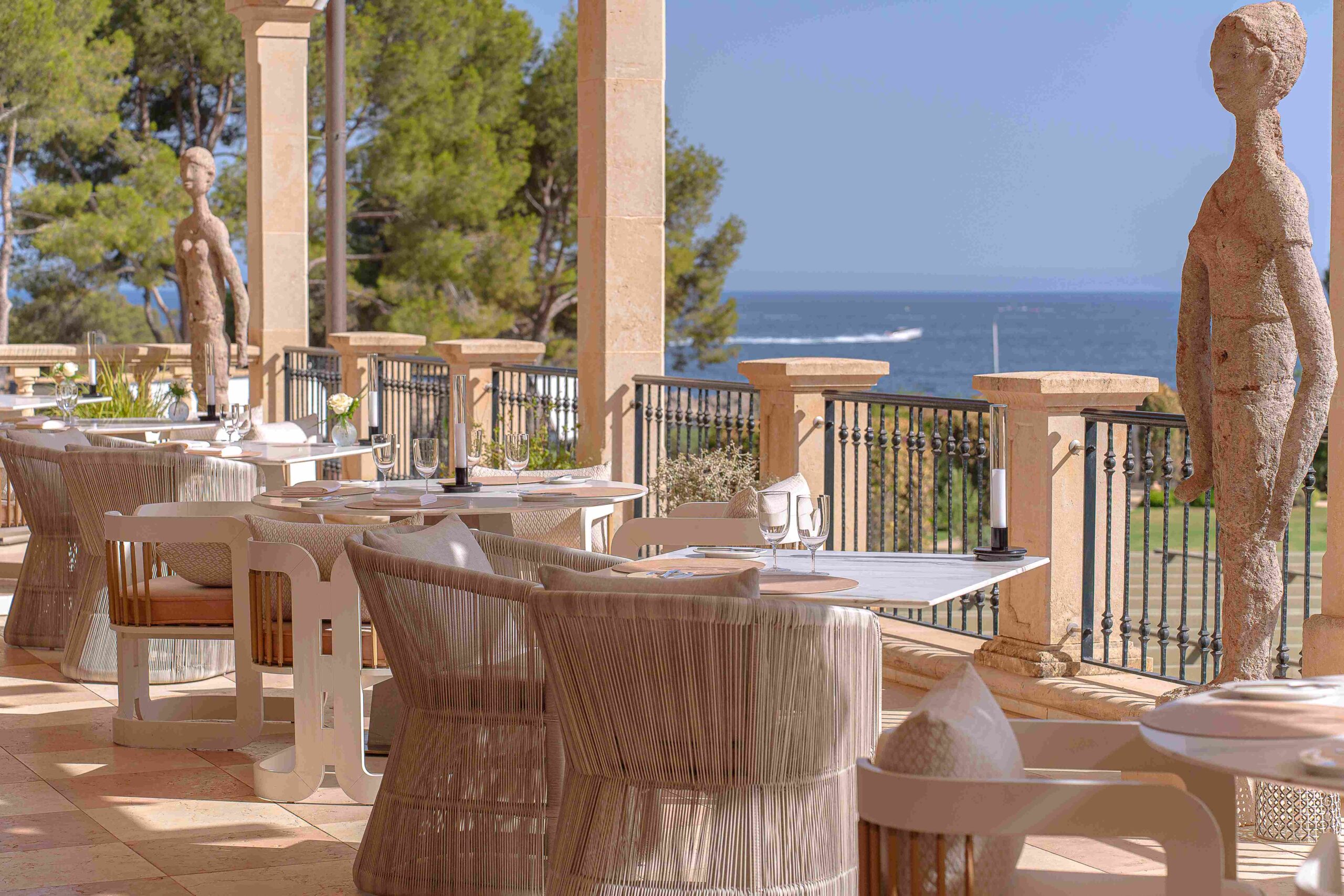 Es Fum bij Palmanova: sterrenkeuken op een terras aan zee 1 Het terras van sterrenrestaurant Es Fum in Costa d'en Blanes op Mallorca met gedekte tafels en uitzicht op zee