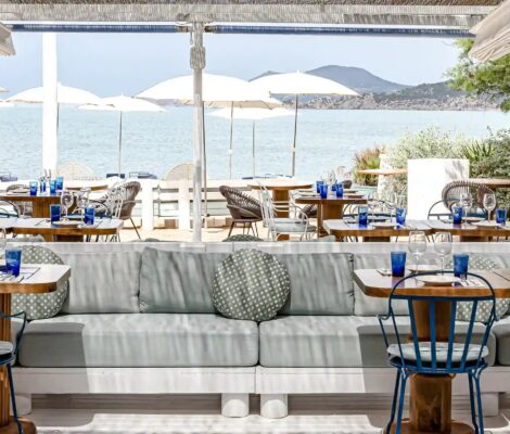 Het terras van Experimental Beach Ibiza met witte parasols en uitzicht over zee