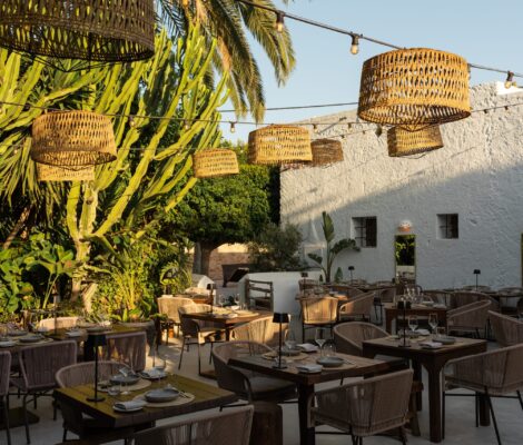 De binnenplaats van Finca La Plaza met citrusbomen, lichtjes en gedekte tafels