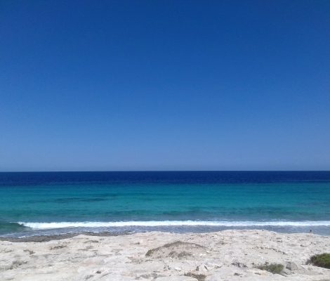 De kust van Ses Illetes op Formentera met wit zand en banden turquoise en diepblauw water