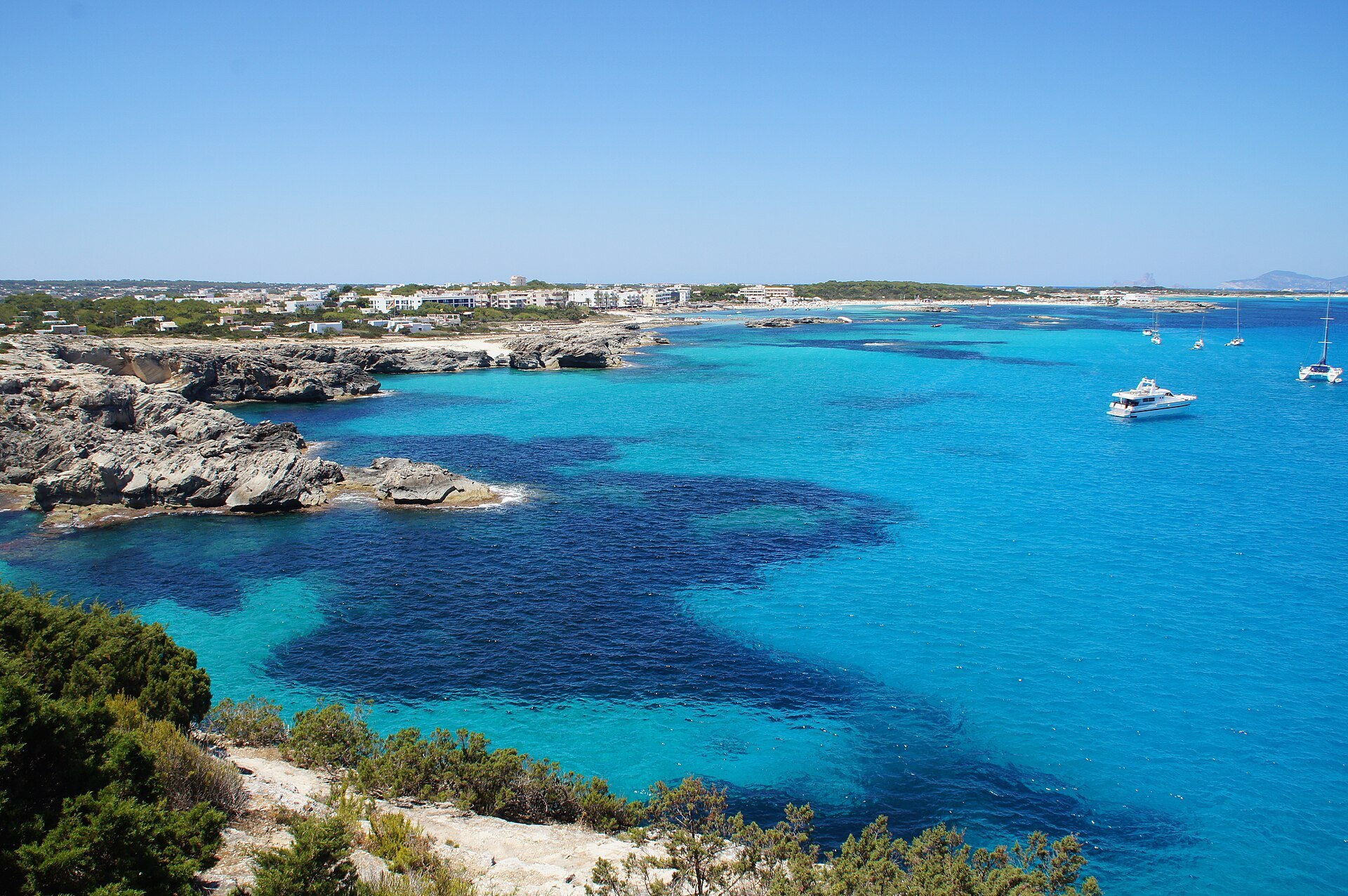 De mooiste stranden van Formentera: alle stranden per kust (gids 2026) 4 De baai van Es Pujols op Formentera met rotskust en posidoniavelden in helder blauw water