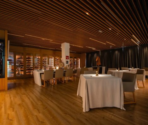 De eetzaal van sterrenrestaurant Fusion19 in Playa de Muro op Mallorca, met houten lattenplafond en gedekte tafels