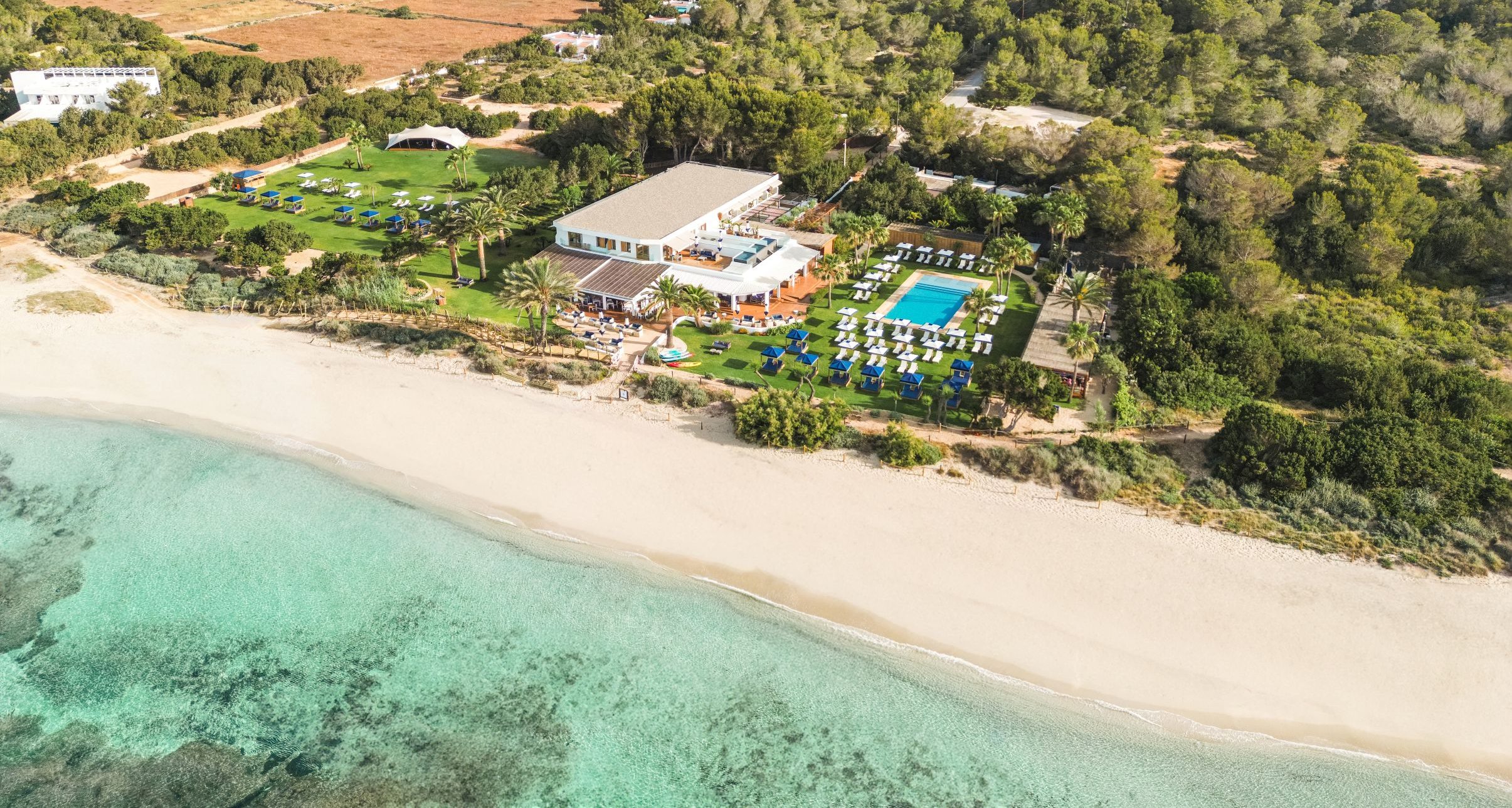 Luchtfoto van Gecko Beach Club aan Platja de Migjorn met de turquoise zee