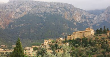 De goedkoopste maand voor de Balearen 16 Het dorp Deia op Mallorca tussen olijfterrassen en de bergen van de Serra de Tramuntana