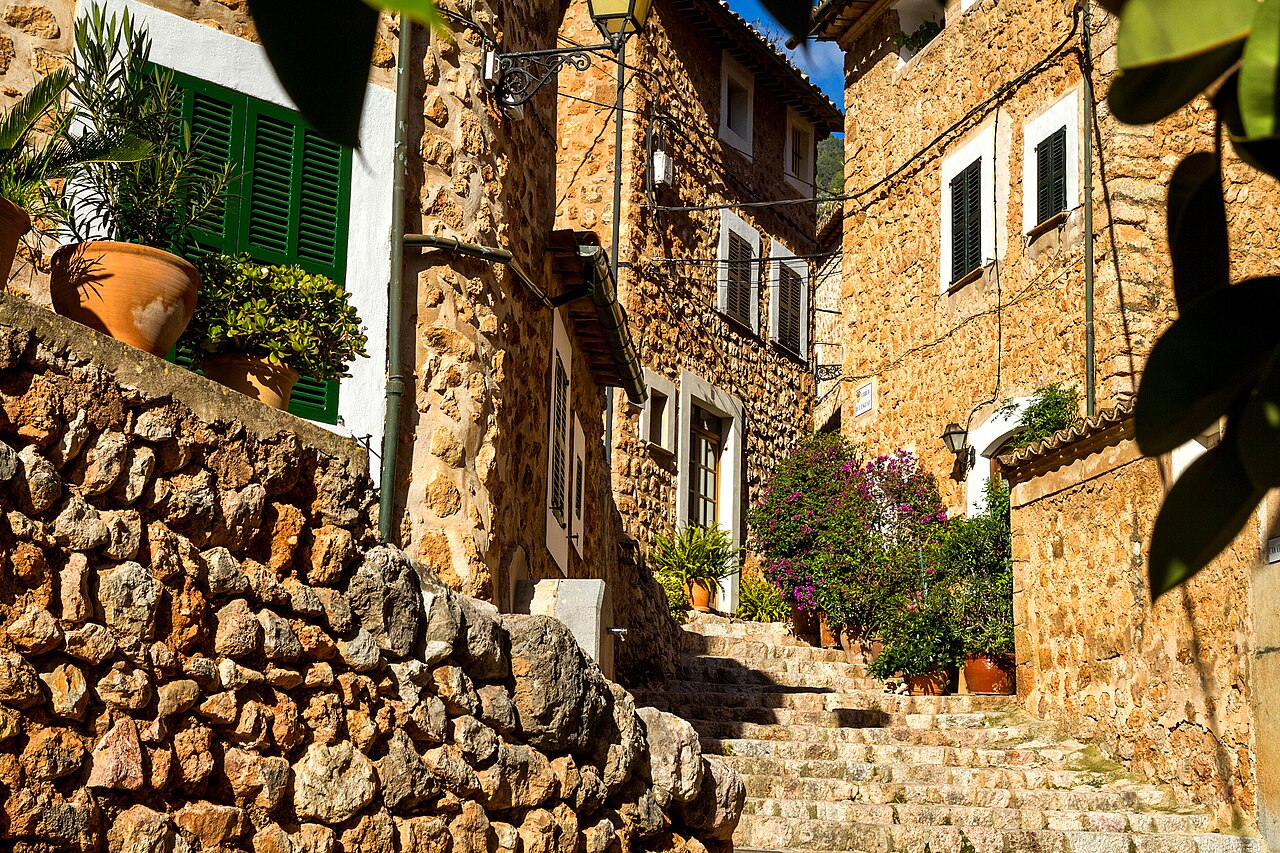 De goedkoopste maand voor de Balearen 3 Stenen trappen tussen de huizen van Fornalutx op Mallorca, met planten langs de treden