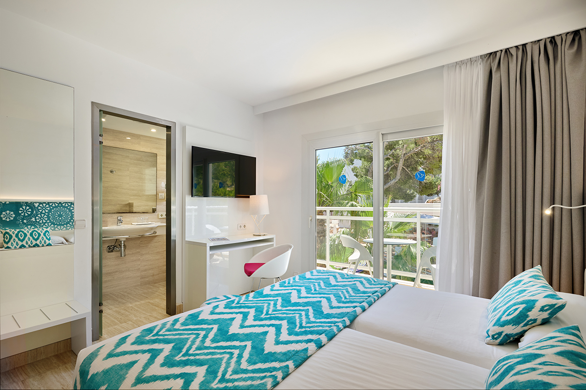 Een tweepersoonskamer met balkon in Grupotel Ibiza Beach Resort in Portinatx