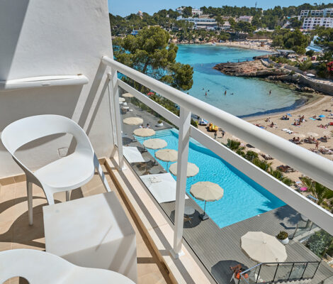 Uitzicht vanaf een balkon van Grupotel Ibiza Beach Resort op het zwembad en het strand van S Arenal Petit in Portinatx