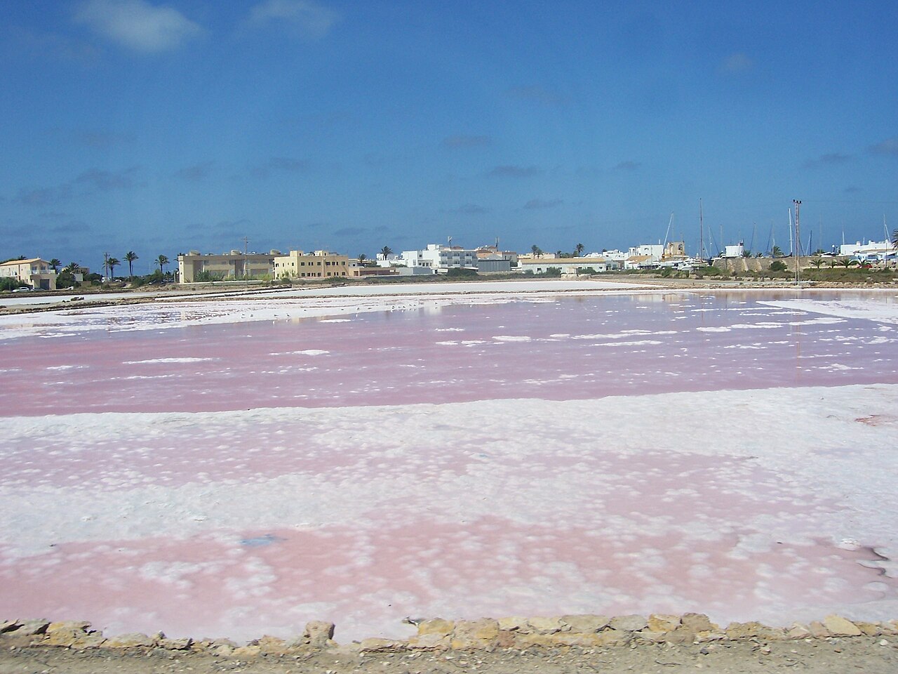Hoe groot is Formentera? Oppervlakte, afmetingen en rijtijden 7 De roze zoutpannen bij La Savina op Formentera, met de huizen van het dorp erachter