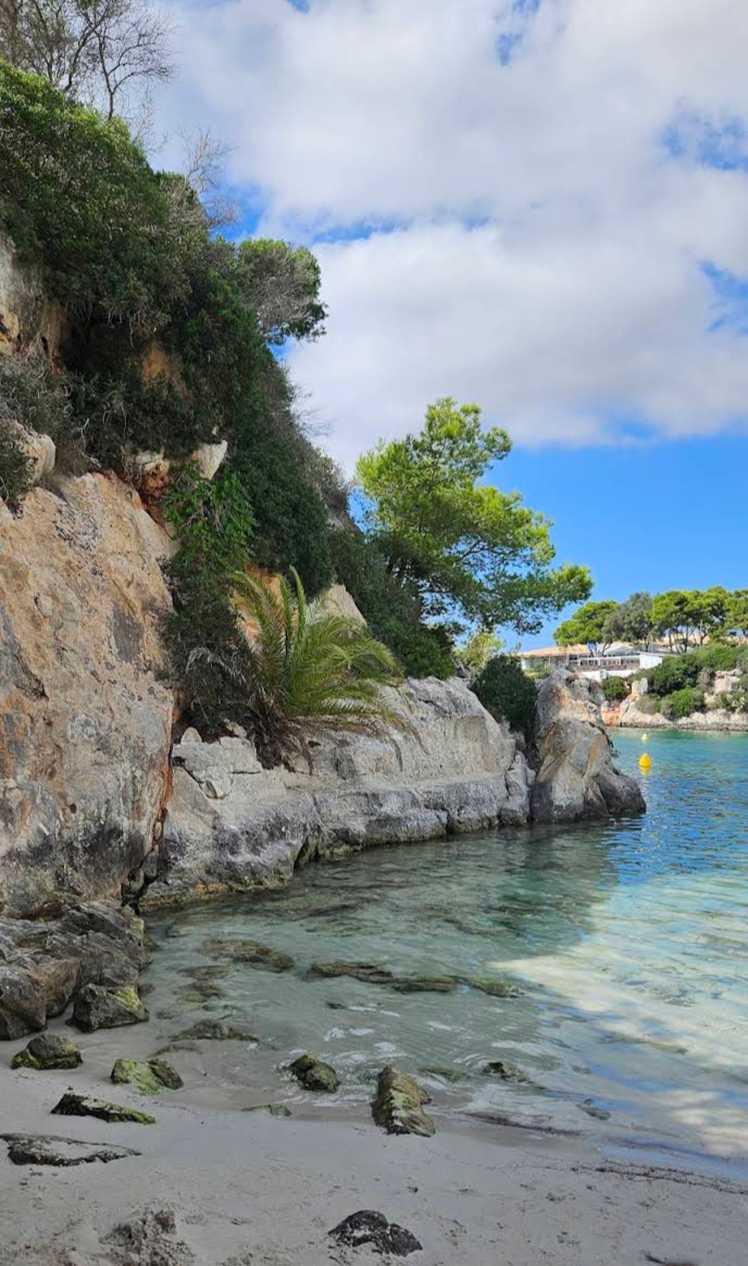 De rotsen en het turquoise water van de cala van Cala en Blanes bij Hopi Beach Bar