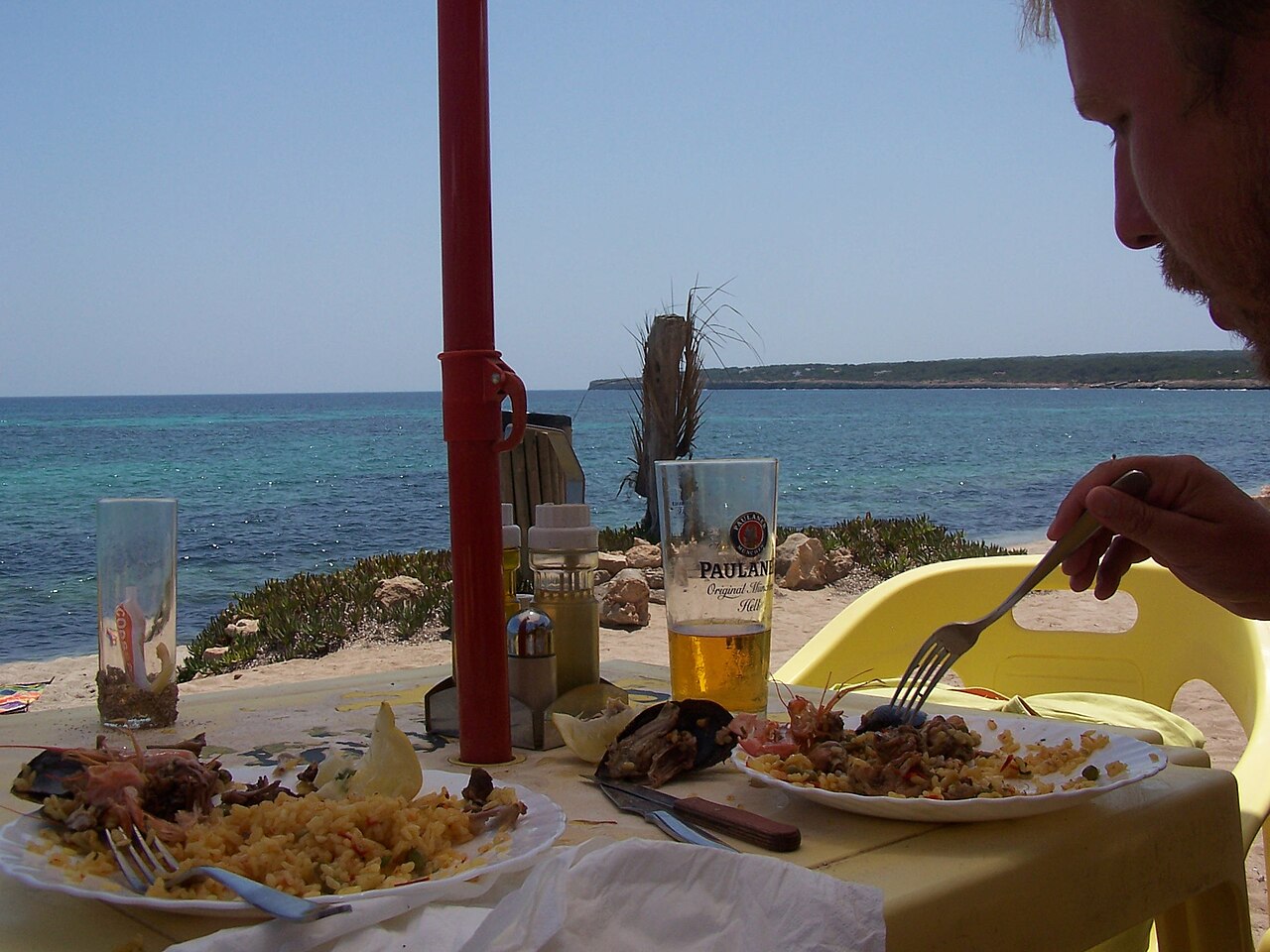 Is Formentera duur? Wat een vakantie in 2026 echt kost 7 Bord met eten en een glas bier op een terras van een strandrestaurant op Formentera