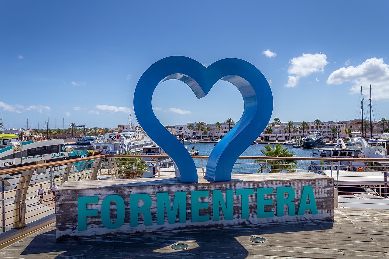 Is Formentera duur? Wat een vakantie in 2026 echt kost 1 Het bord met de naam Formentera aan de haven van La Savina, met masten op de achtergrond