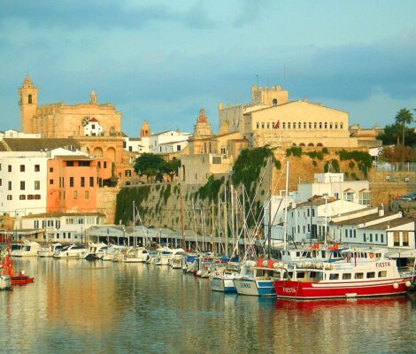 De haven van Ciutadella op Menorca met gekleurde huizen en terrassen boven de kade