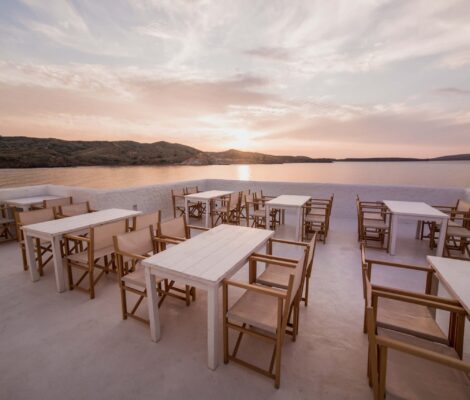 Het witte terras van Isabella Beach Club op de rotsen bij Platges de Fornells bij zonsondergang