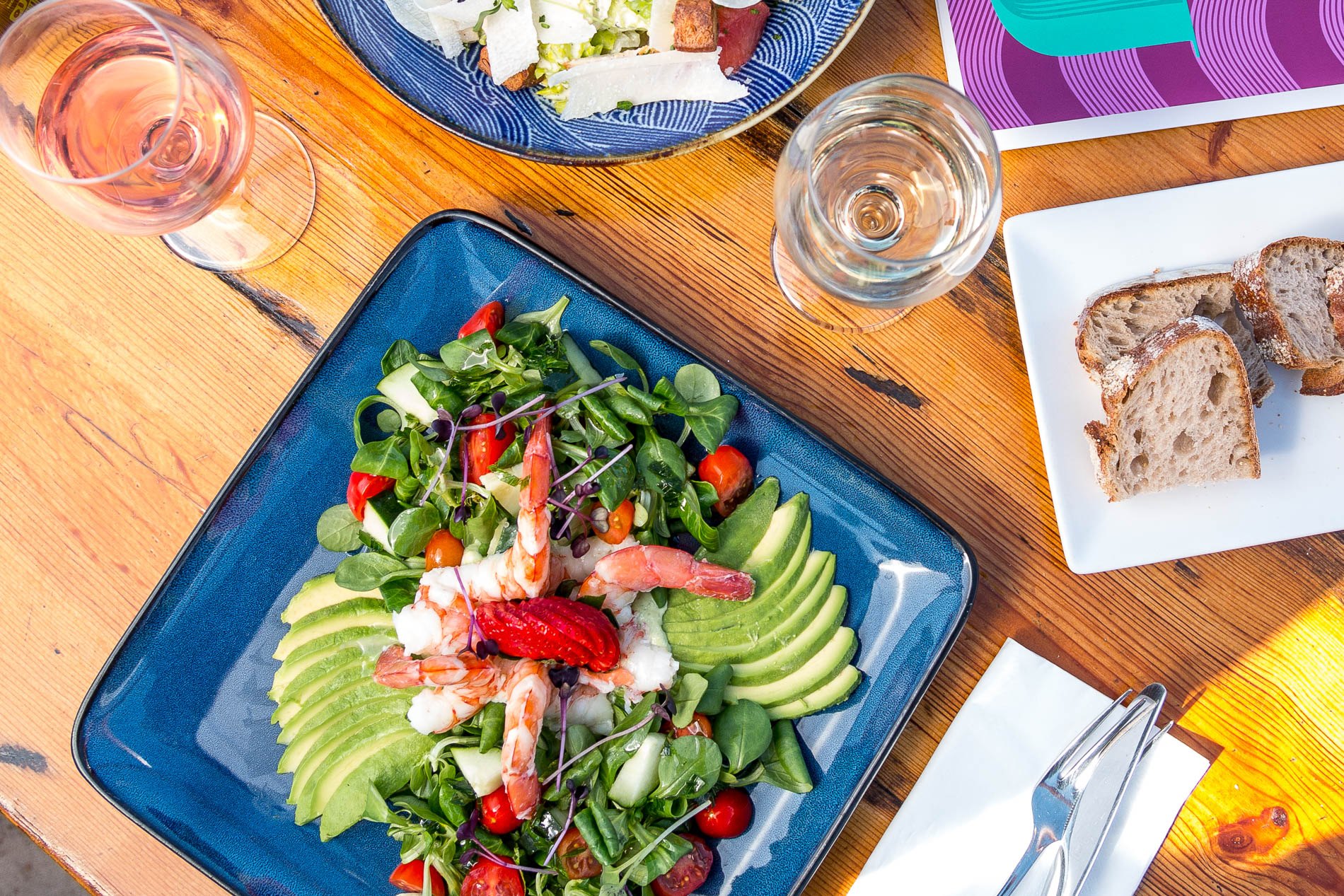 Salade met garnalen en avocado op een houten tafel van Jockey Club