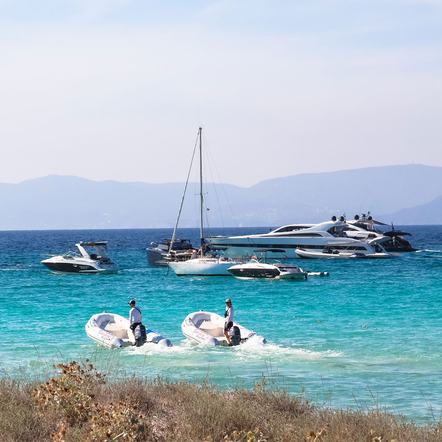 Juan y Andrea Formentera: het strandrestaurant voor de jachten op Ses Illetes 3 Jachten en een tender in de turquoise baai voor Juan y Andrea op Ses Illetes