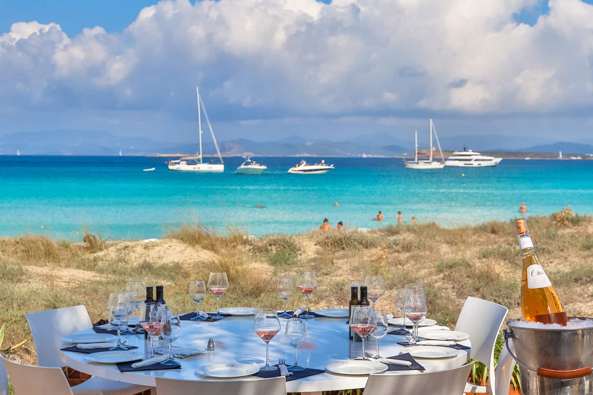 Juan y Andrea Formentera: het strandrestaurant voor de jachten op Ses Illetes 1 Gedekte tafel op het zand van Ses Illetes bij Juan y Andrea met jachten in de baai